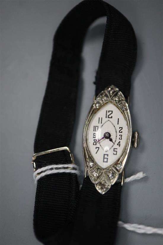 A ladys late 1920s 18ct white gold and diamond set manual wind cocktail watch, on a fabric strap, gross 9.5 grams.